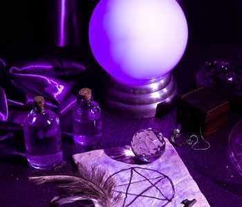 A glowing crystal ball with purple glass bottles and a parchment sigil
